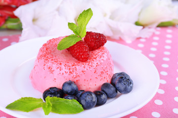 Round shaped cake with berries on plate on polka dot table