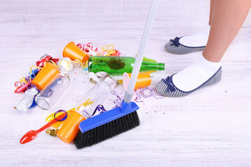 Woman cleaning grey wooden floor from mess