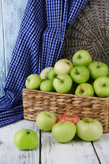Ripe apples in basket on table close-up