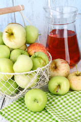 Ripe apples and juice in basket on table close-up
