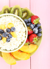 Cottage cheese with fruits and berries in bowl on wooden table