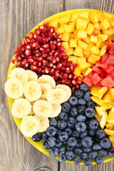 Sliced fruits on plate on wooden table