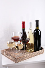 Fototapeta premium Bottles and glasses of wine on table in room