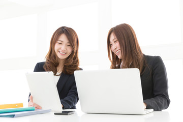 パソコンとタブレットを見る二人の女性　ビジネス 