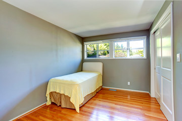 Empty house interior. Grey bedroom with single bed