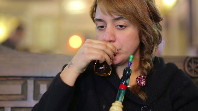secular turkish woman smoking shisha at nargile cafe shop