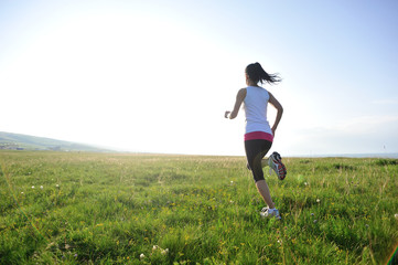 Runner athlete legs running on  grass seaside