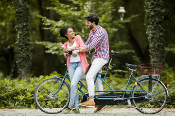 Obraz premium Young couple riding on the tandem bicycle
