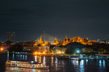 Grand palace and cruise ship in night ,Bangkok city ,Thailand