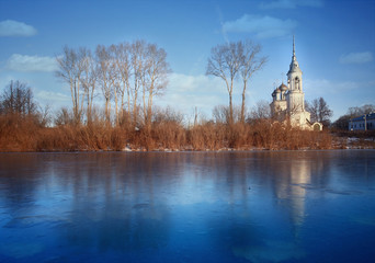 Church on the banks of the frozen river ice winter