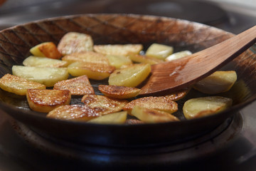 Bratkartoffeln in Eisenpfanne mit Pfannenwender