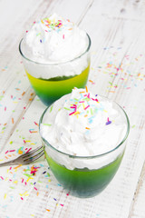 Multicolored jelly with whipped cream and candy topping
