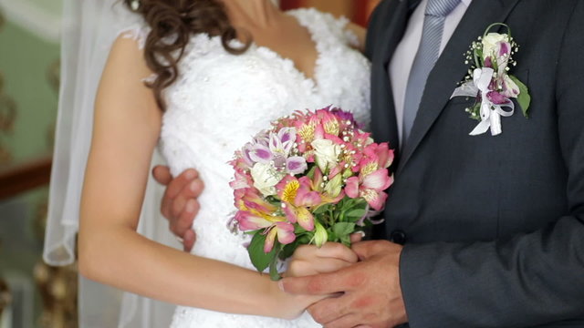 Bride and groom holding bridal bouquet
