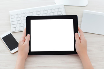 female hands holding a tablet with a isolated screen over a tabl