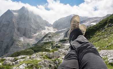 Pair of leggs stretched into the air with a mountain view