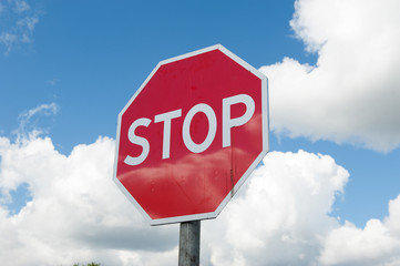 Stop sign over blue sky background