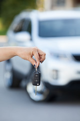 Suv defocused on background and woman hand with ignition key