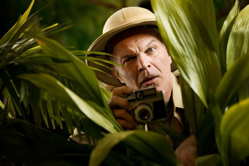 Explorer photographer hiding in vegetation
