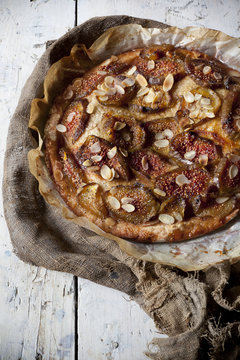 whole rustic figs tart with almond slices on vintage set