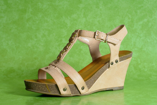 Sandalo, scarpa alta marrone, sfondo verde, tacco