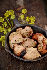 Pieces of grilled meat in a frying pan