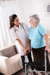 cheerful young rehab nurse helping elderly woman using a walker