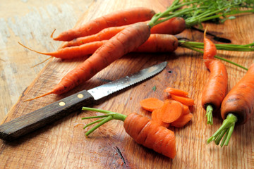Cutted carrots with knife on a wooden board