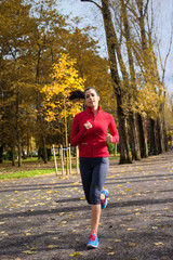 Fototapeta premium Female athlete running in autumn park