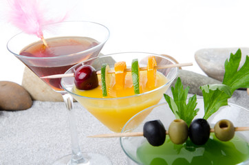 Orange, cherry and green vegetables cocktails on a beach environ