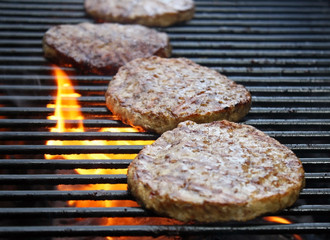 Burgers Cooking Over Flames On The Grill
