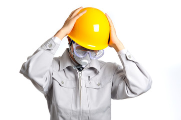 ヘルメットをかぶって頭を抱えている作業服の男性