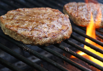Burgers Cooking Over Flames On The Grill