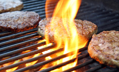 Burgers Cooking Over Flames On The Grill