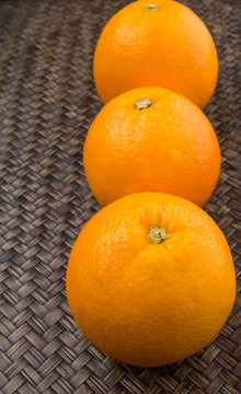 Orange fruits over wicker background 