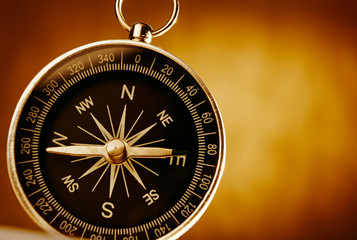 Magnetic compass against a vintage background