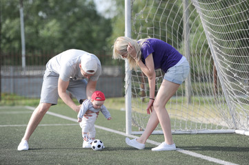 the father, mother and the kid play soccer