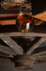 Fototapeta na wymiar Glass of brandy on wooden wheel