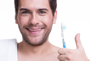 Happy young man with a toothbrush.