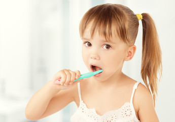 happy little girl brushing her teeth