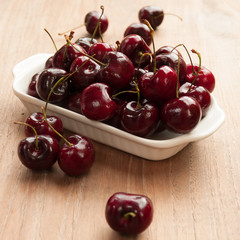 Fresh cherries in bowl on table