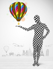 man in full body suit holding balloon