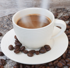 White cup in coffee beans, closeup