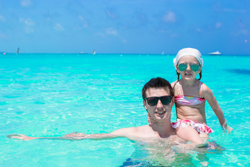 Happy father play with little daughter in perfect sea