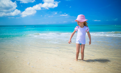 Cute little girl playing in shallow water at exotic beach