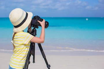 Little girl shooting with camera on tripod during her summer