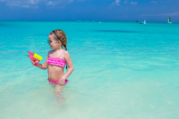 Fototapeta na wymiar Cute little girl playing with toys during caribbean vacation