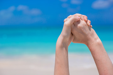 Close up of female hands on white sandy beach