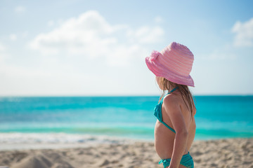 Adorable little girl in hat on beach during summer vacation