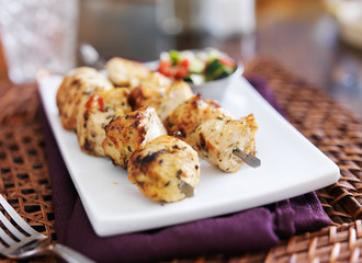 two grilled chicken kabab with cucumber salad
