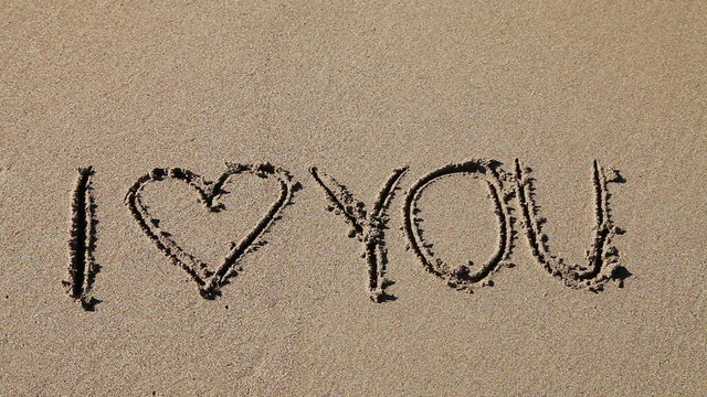 I Love you written in the sand being washed away